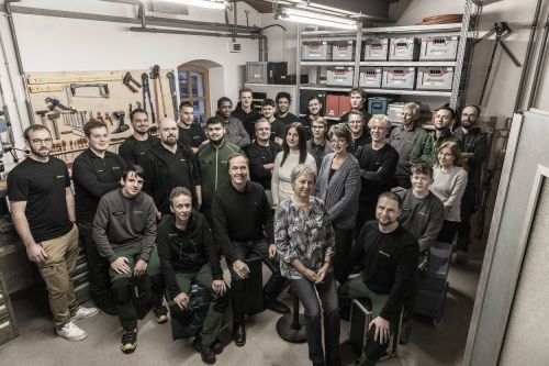 Eine Gruppe von Menschen posiert in einer Werkstatt für Sanitär- und Klimatechnik für ein Teamfoto 2024.