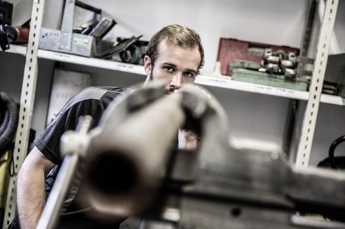 Ein Techniker arbeitet konzentriert an einem Gerät in der Werkstatt, spezialisiert auf moderne Klimatechnik.