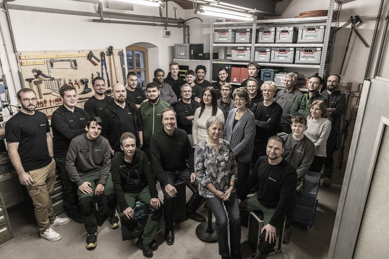 Eine Gruppe von Menschen posiert in einer Werkstatt für Sanitär- und Klimatechnik für ein Teamfoto 2024.